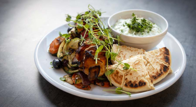 Chicken breast skewers with grilled vegetables, tzatziki sauce and pita bread