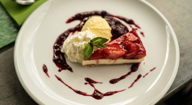 Strawberry cheesecake with strawberry coulis and vanilla ice cream